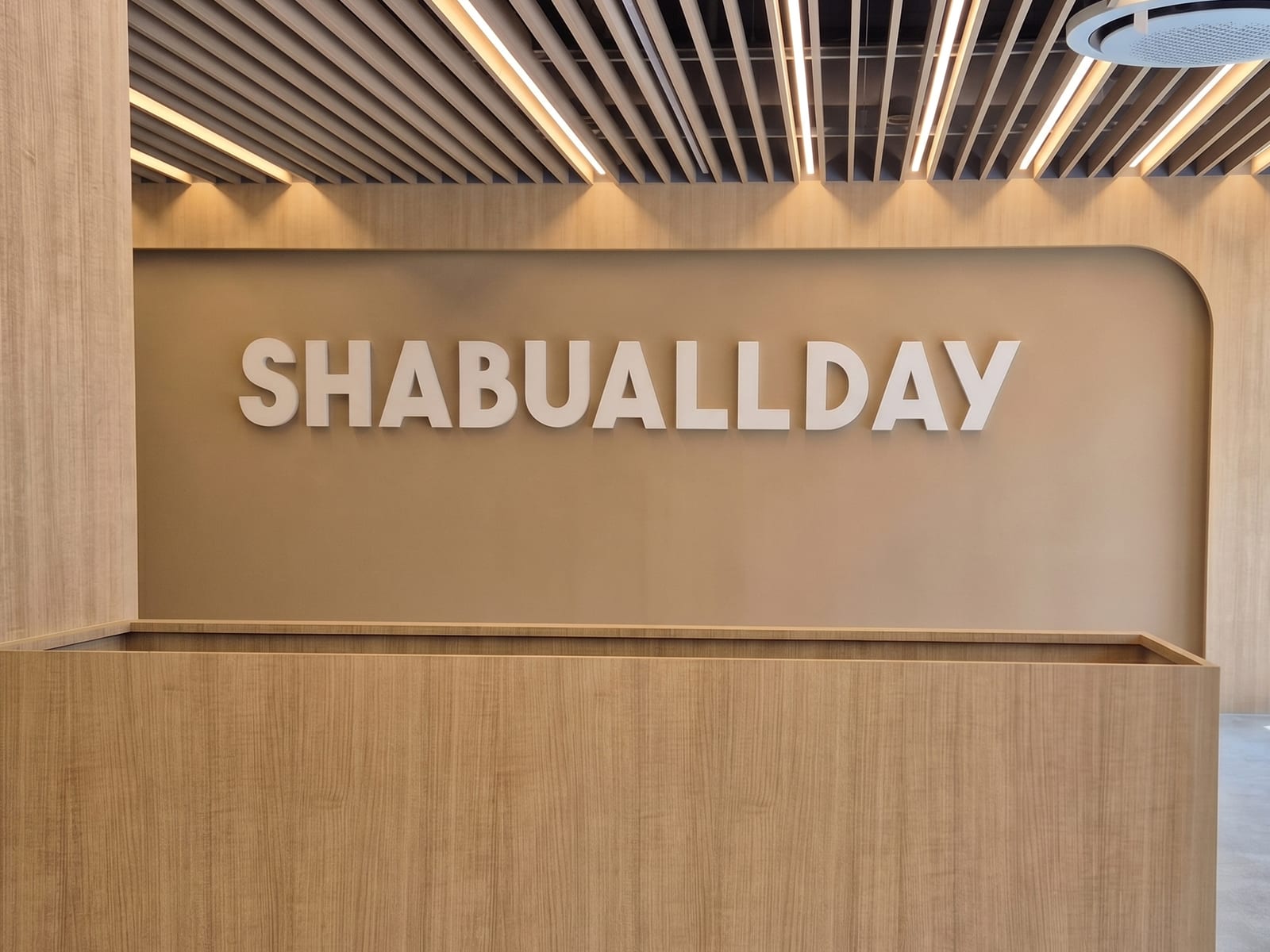 춘천 샤브올데이 — 시공 전 목재 마감 카운터와 SHABUALLDAY 로고만 있던 벽면