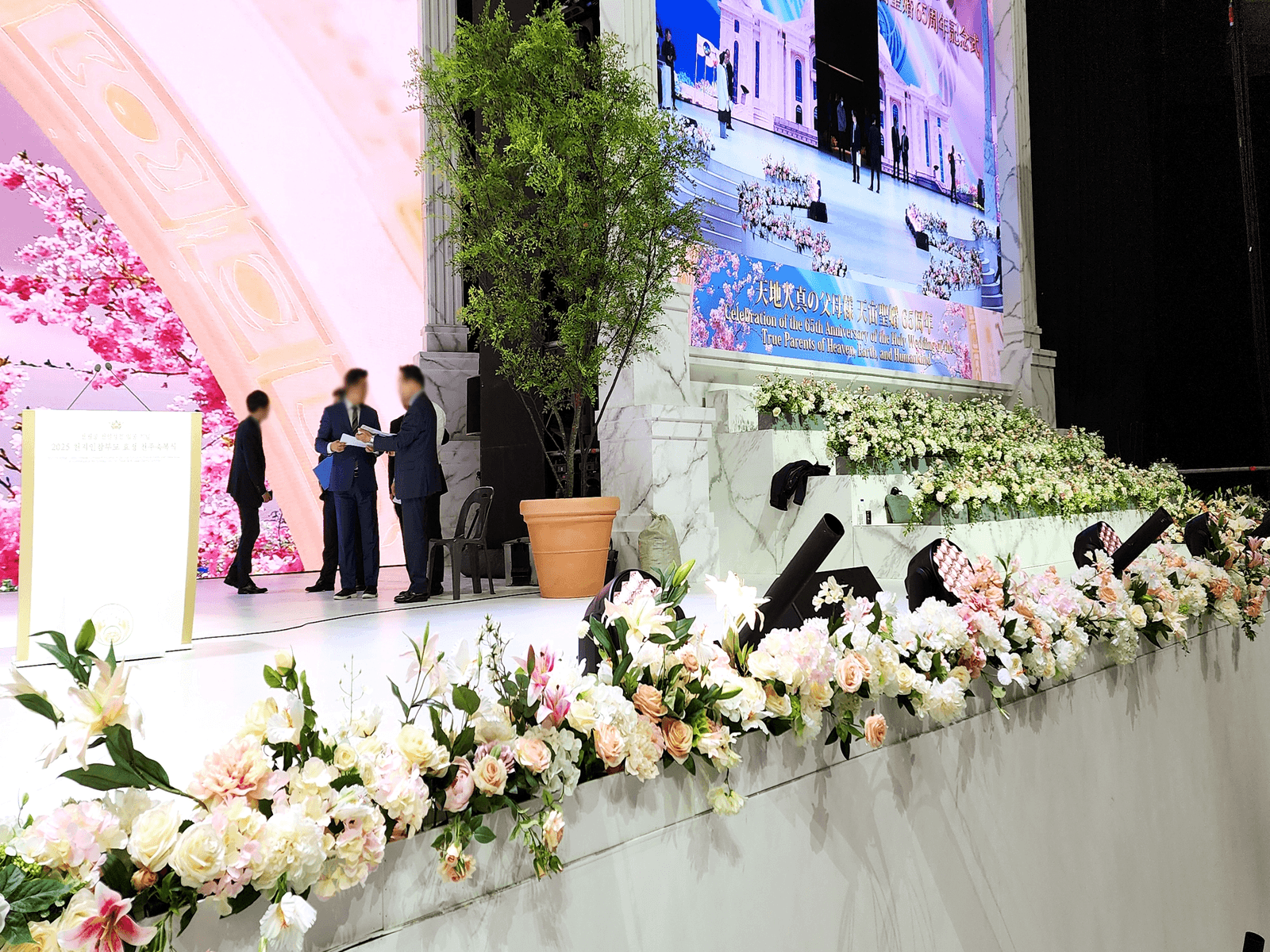 경기 가평 행사장 — 무대 단상 앞 라인을 따라 카메라 프레임 하단에 걸리는 꽃 띠