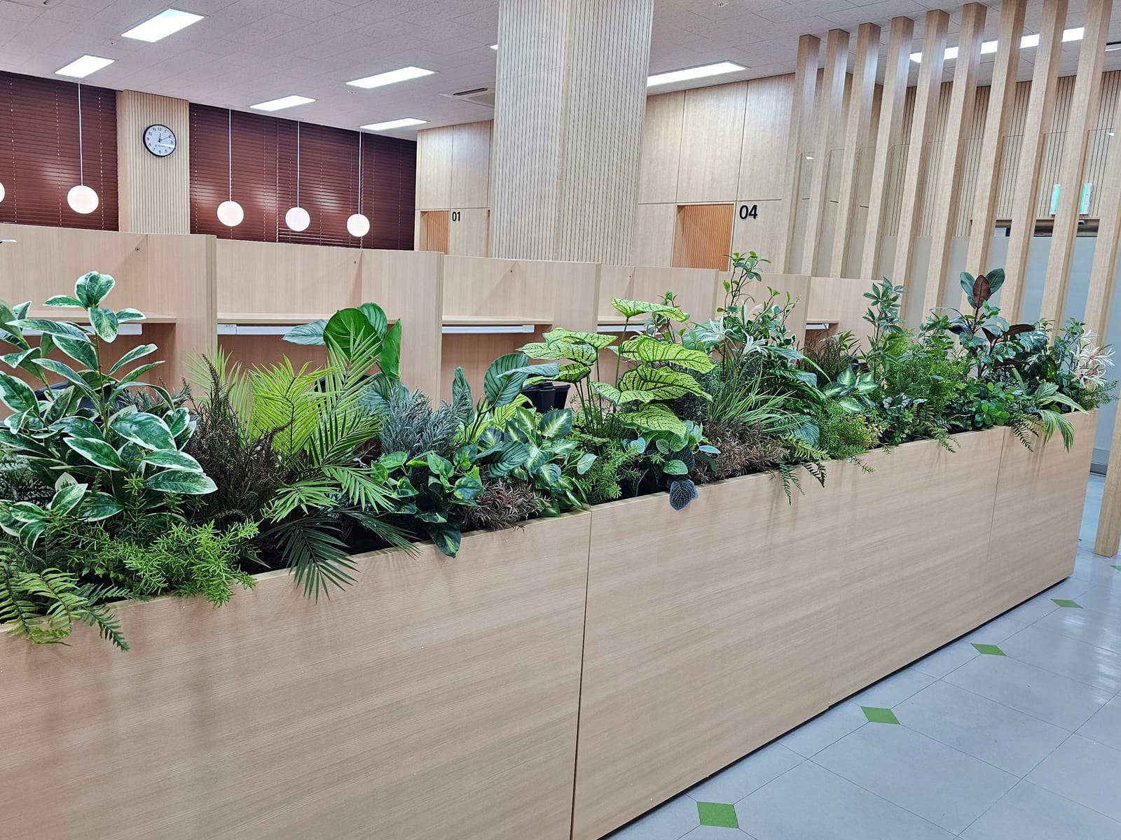 천안 연암대학교 도서관 — 우드톤 열람 부스와 같은 톤의 플랜트박스에 담긴 풍성한 인조 식물