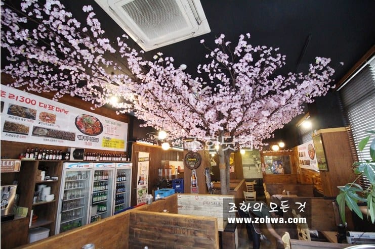 인천 닭권브이치킨토리 300점 — 목재 매장 위로 펼쳐진 벚꽃