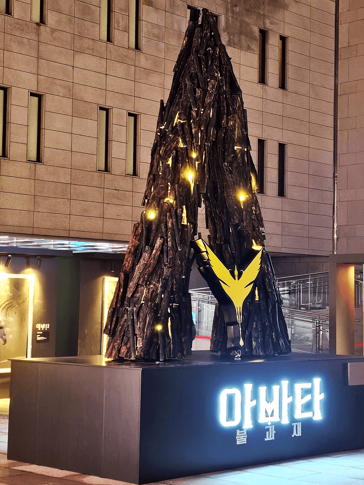서울 세종문화회관 — 측면에서 본 거대 A자 랜드마크 조형물과 황금 엠블럼, 밤 조명