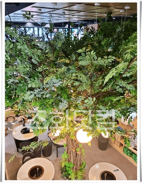 고양 라페스타 제주몬딱 라페스타점 — 낮은 조도의 홀에서도 잎 색이 살아 있는 대형 인조나무