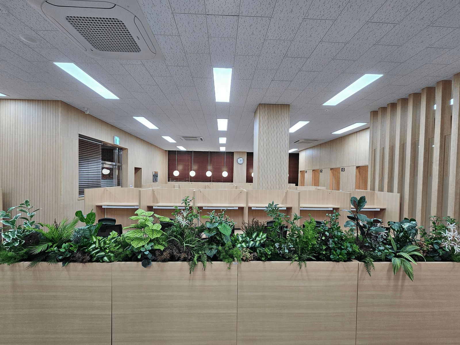 충남 천안 연암대학교 도서관 — 우드 톤 가구와 플랜트박스 초록이 어우러진 열람실 전경