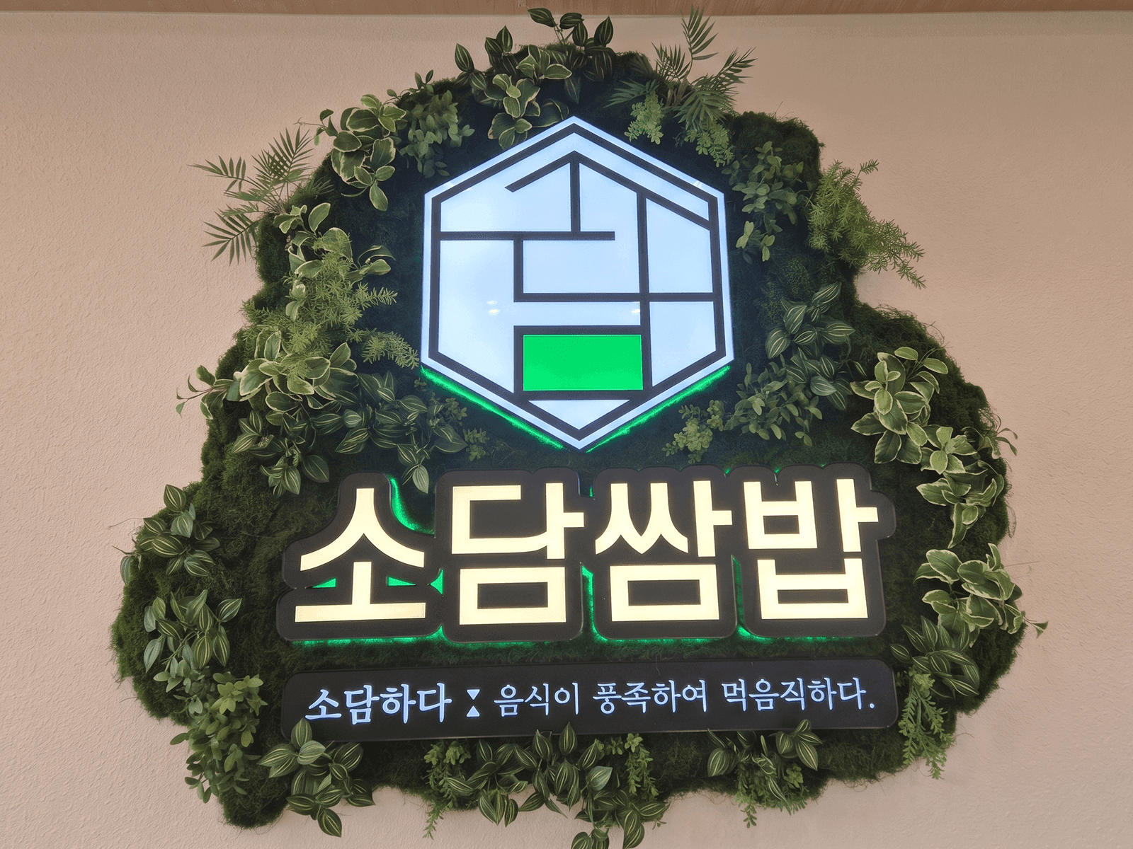 보령시 소담쌈밥 — 실내 벽에 매장 로고를 인조 이끼로 둥글게 감싸 만든 브랜드 사인