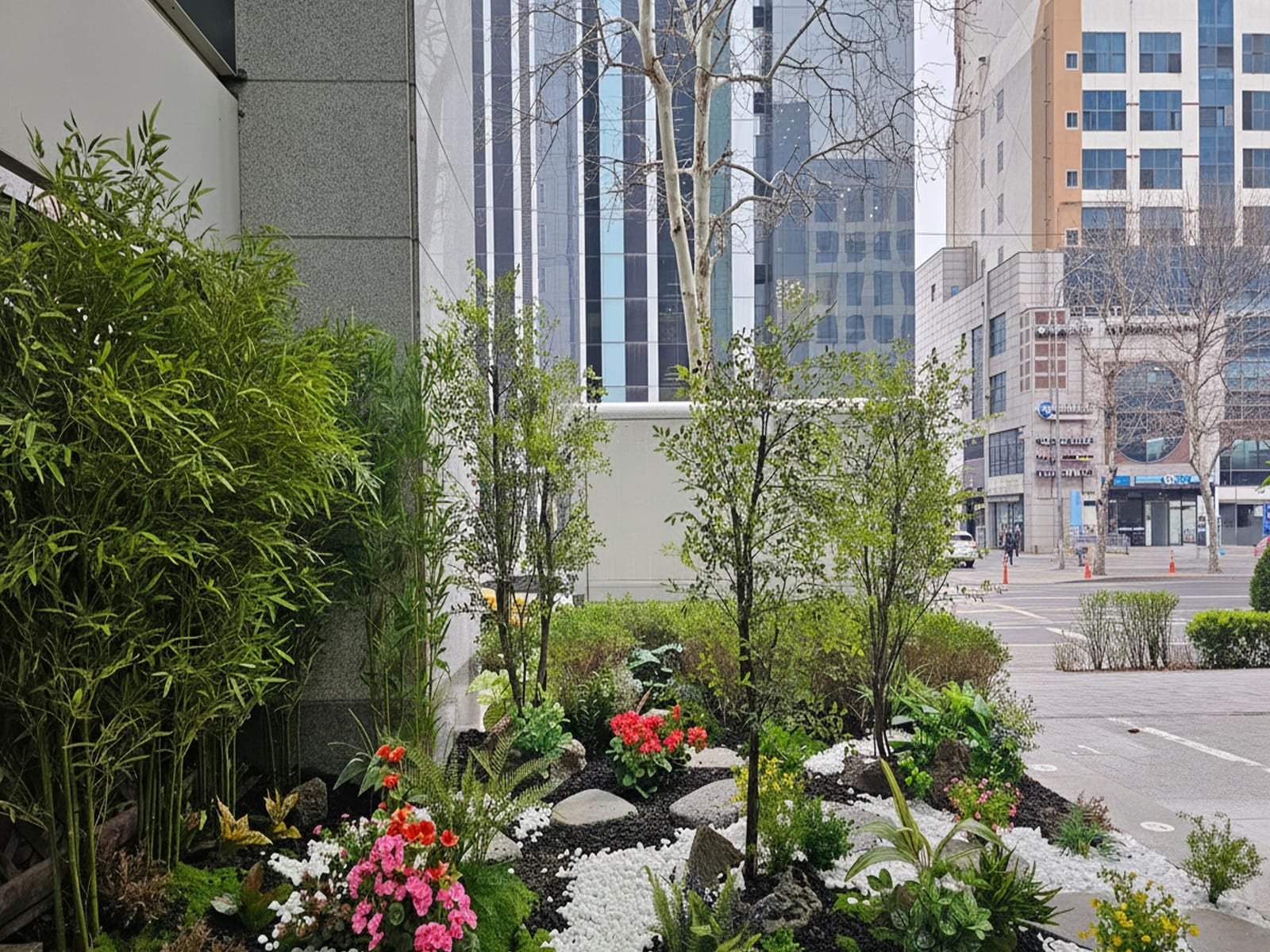 서울 강남 상가 — 시원하게 뻗은 인조 대나무와 나무, 꽃이 어우러진 상가 앞 정원 전경