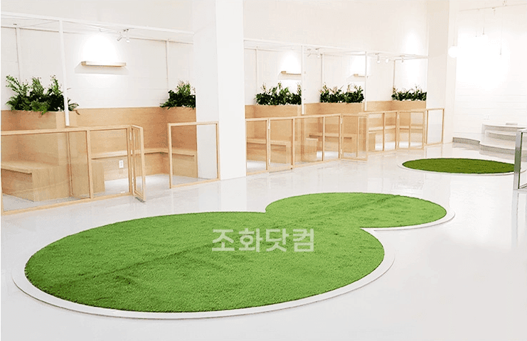 서울 글램독 그라운드 삼성점 — 인조 잔디가 깔린 강아지 놀이공간과 부스 위에 둔 인조 식물 화단