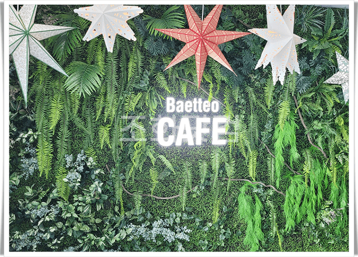 인천 영종도 뱃터 카페 — 별 모양 조화장식과 'Baetteo CAFE' 네온이 어우러진 초록 벽