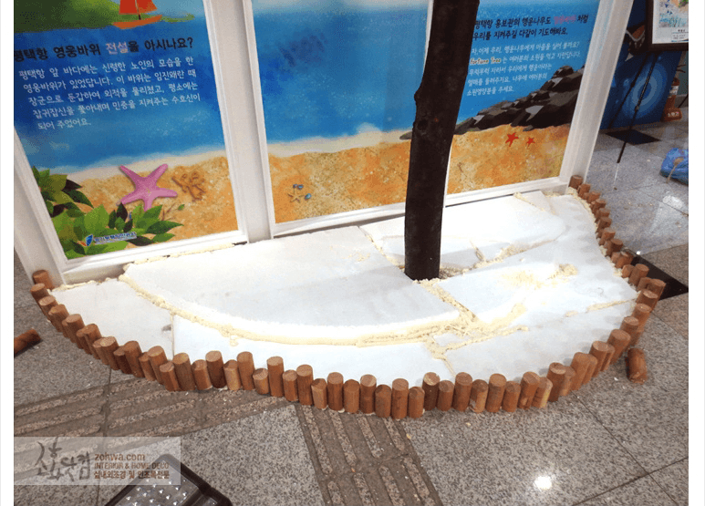 평택항 홍보관 — 흰 자갈과 경계목으로 마감한 원형 화단