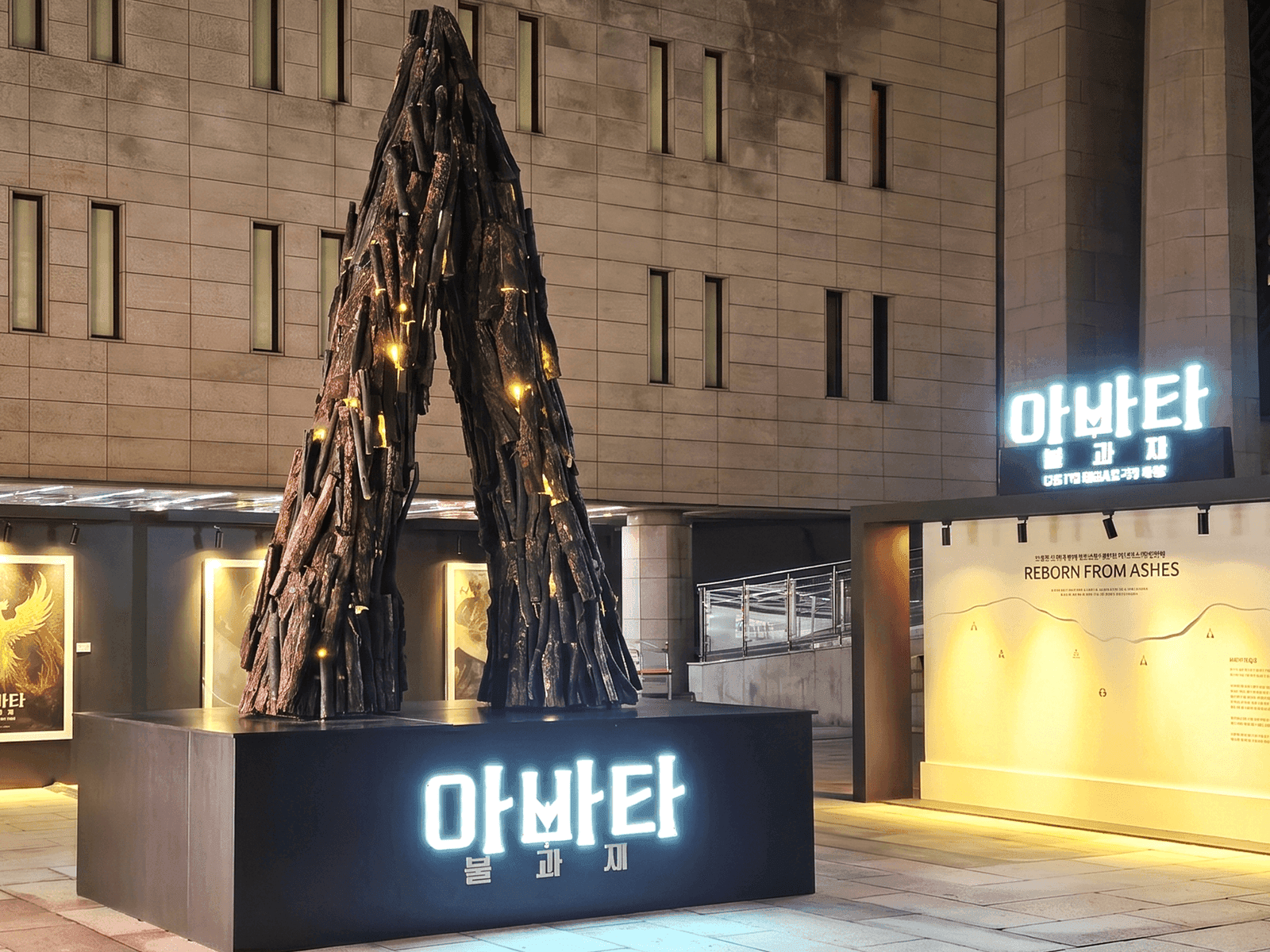 서울 세종문화회관 — 측면에서 본 A자 행사장 조형물과 'REBORN FROM ASHES' 사인, 밤 조명